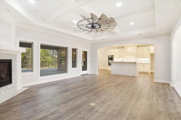 a view of an empty room with a window and wooden floor