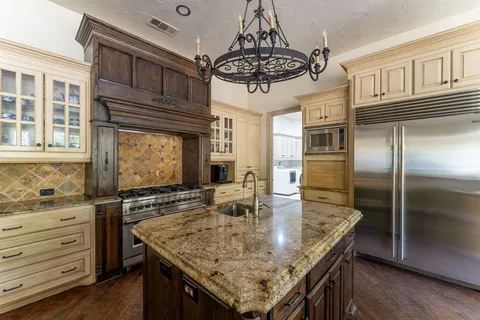 a kitchen with stainless steel appliances granite countertop a sink and cabinets