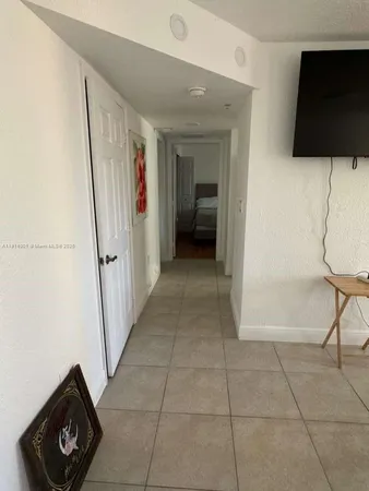 a view of a hallway to a livingroom with furniture