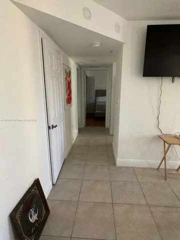 a view of a hallway to a livingroom with furniture