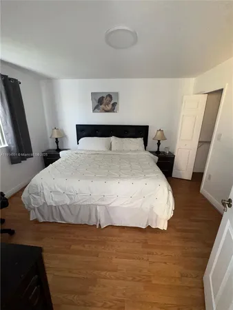 a large bed sitting in a bedroom next to a window