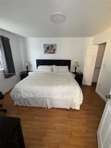 a large bed sitting in a bedroom next to a window