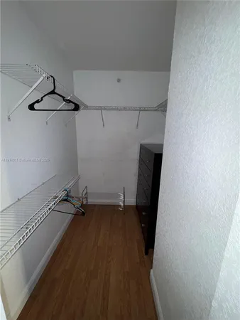 a view of a room with wooden floor and cabinets