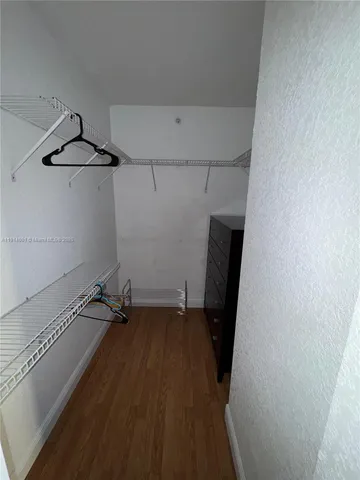 a view of a room with wooden floor and cabinets