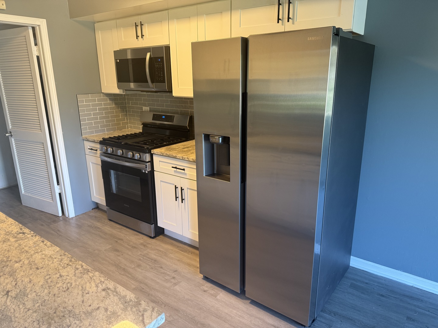 1319 Kingsbury Drive, Unit 2 Hanover Park, IL 60133 - Photo 11 of 44 a metallic refrigerator freezer sitting in a kitchen