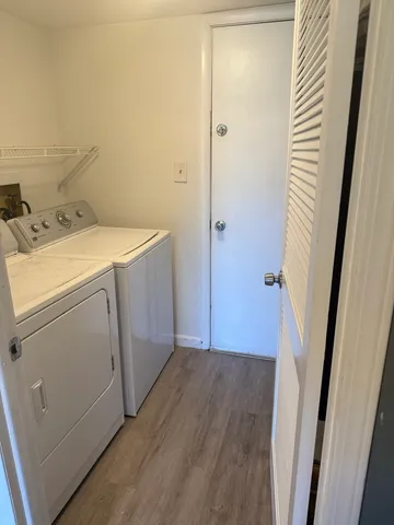a utility room with wooden floor washer and dryer