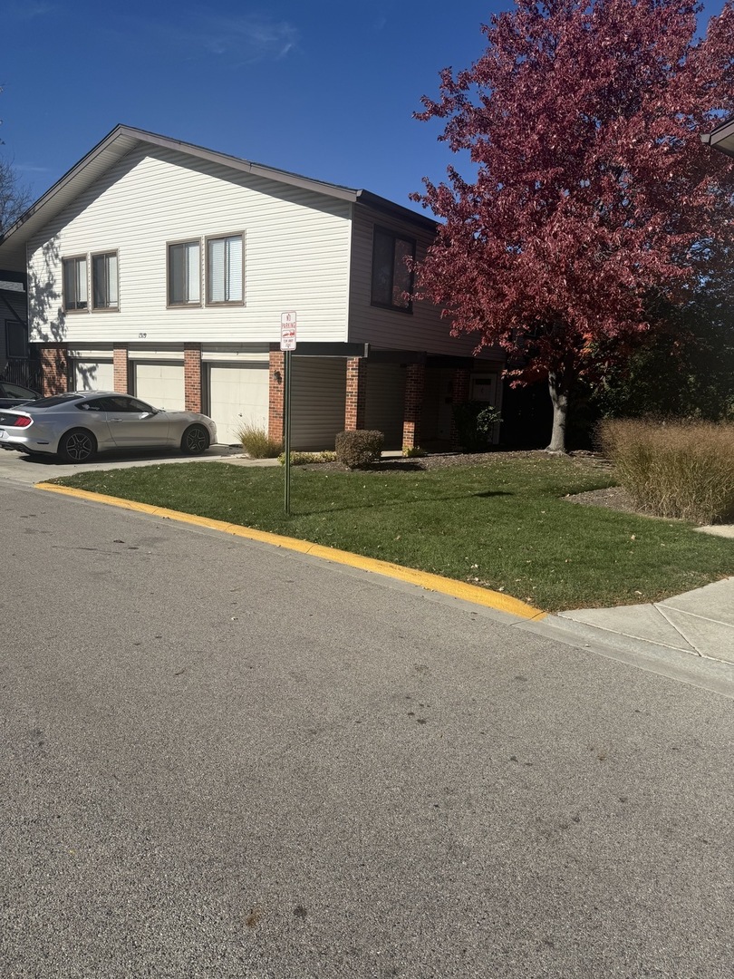 1319 Kingsbury Drive, Unit 2 Hanover Park, IL 60133 - Photo 2 of 44 a view of a house with a yard and large tree
