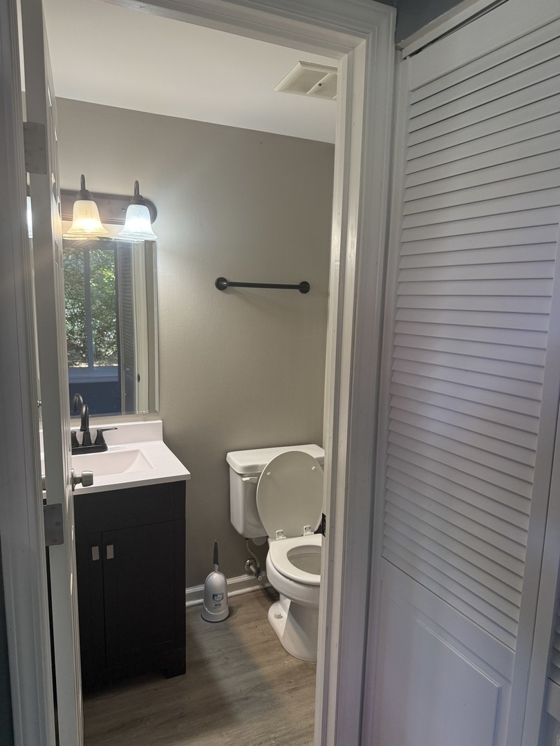1319 Kingsbury Drive, Unit 2 Hanover Park, IL 60133 - Photo 23 of 44 a bathroom with a granite countertop toilet a sink and a mirror