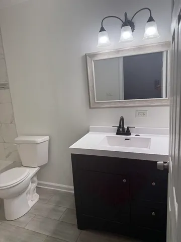 a white toilet and tub sitting next to a bathroom sink