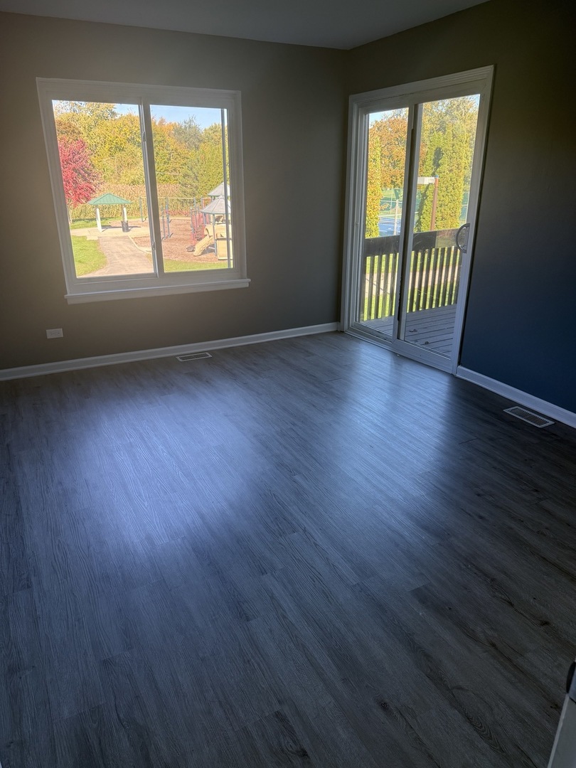 1319 Kingsbury Drive, Unit 2 Hanover Park, IL 60133 - Photo 37 of 44 an empty room with wooden floor and windows
