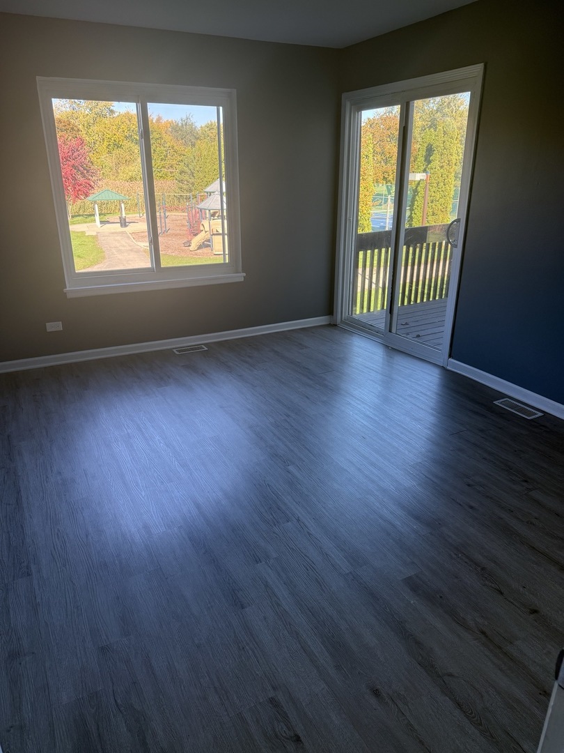 1319 Kingsbury Drive, Unit 2 Hanover Park, IL 60133 - Photo 38 of 44 an empty room with wooden floor and windows