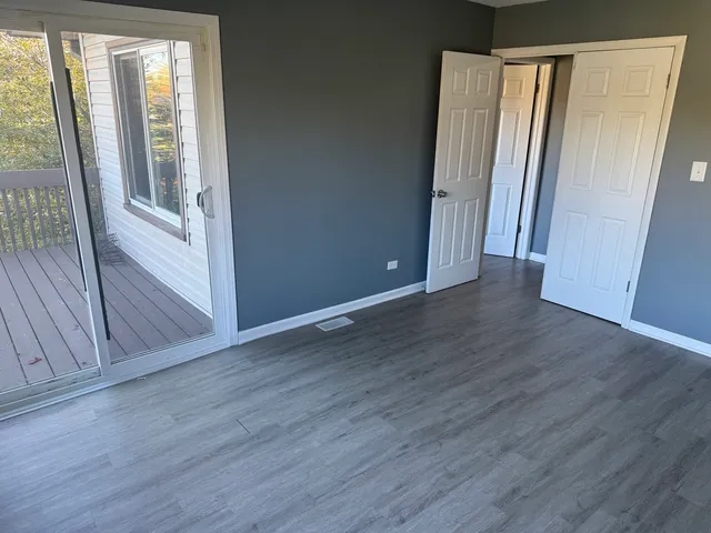 an empty room with wooden floor and closet