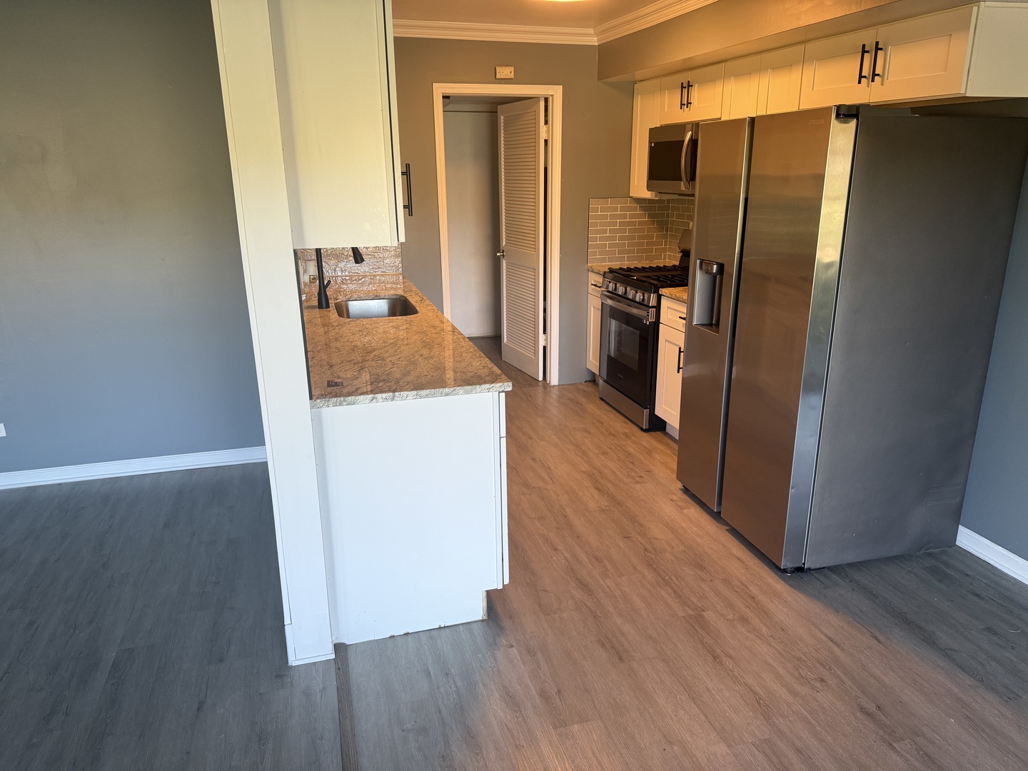 1319 Kingsbury Drive, Unit 2 Hanover Park, IL 60133 - Photo 9 of 44 a kitchen with a refrigerator sink and wooden floor