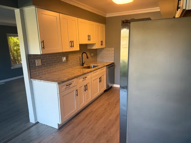 a kitchen with a sink cabinets and wooden floor