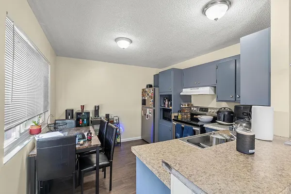 a kitchen that has a lot of cabinets in it and wooden floor