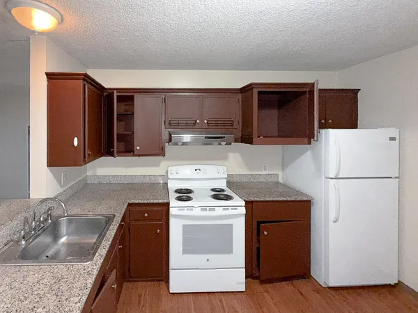 a view of an empty room with wooden floor and closet