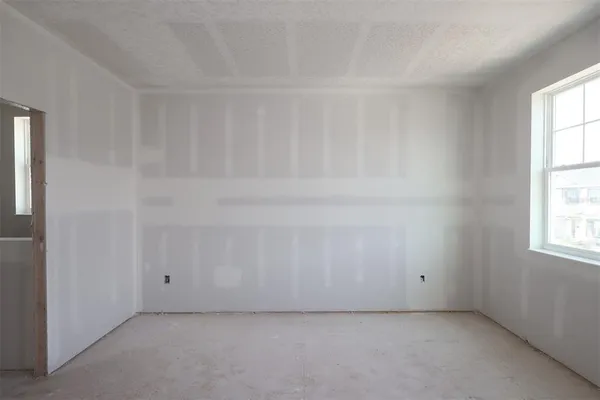 an empty room with windows and closet