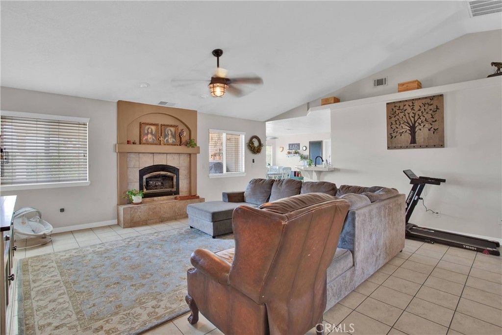 7330 Smoke Tree Road Phelan, CA 92371 - Photo 12 of 46 a living room with furniture a fireplace and a flat screen tv