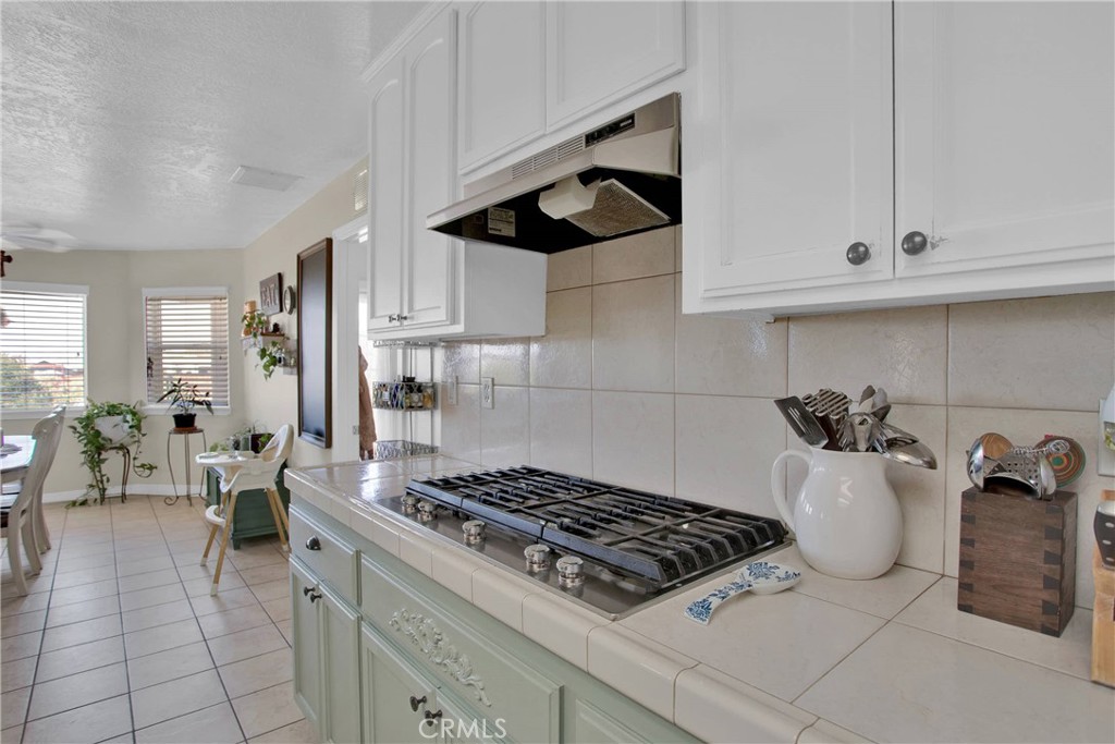 7330 Smoke Tree Road Phelan, CA 92371 - Photo 18 of 46 a kitchen with granite countertop a stove and white cabinets