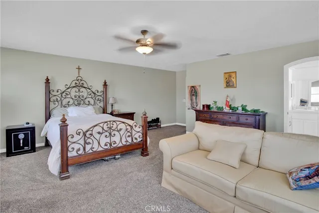 a bedroom with a large bed and a couch