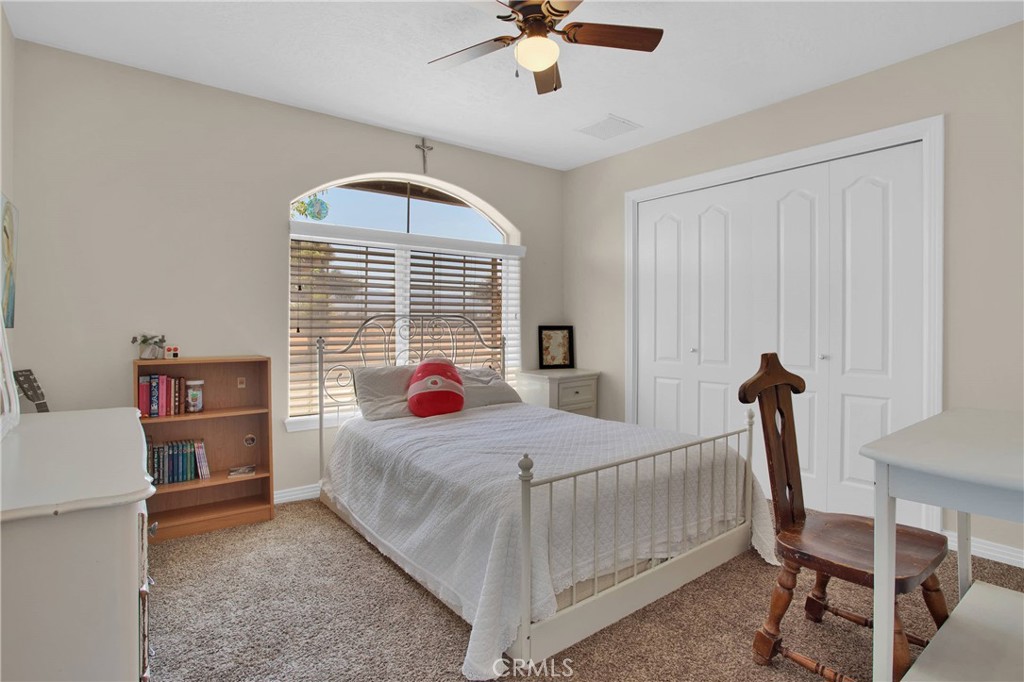 7330 Smoke Tree Road Phelan, CA 92371 - Photo 29 of 46 a bedroom with a bed and a chandelier