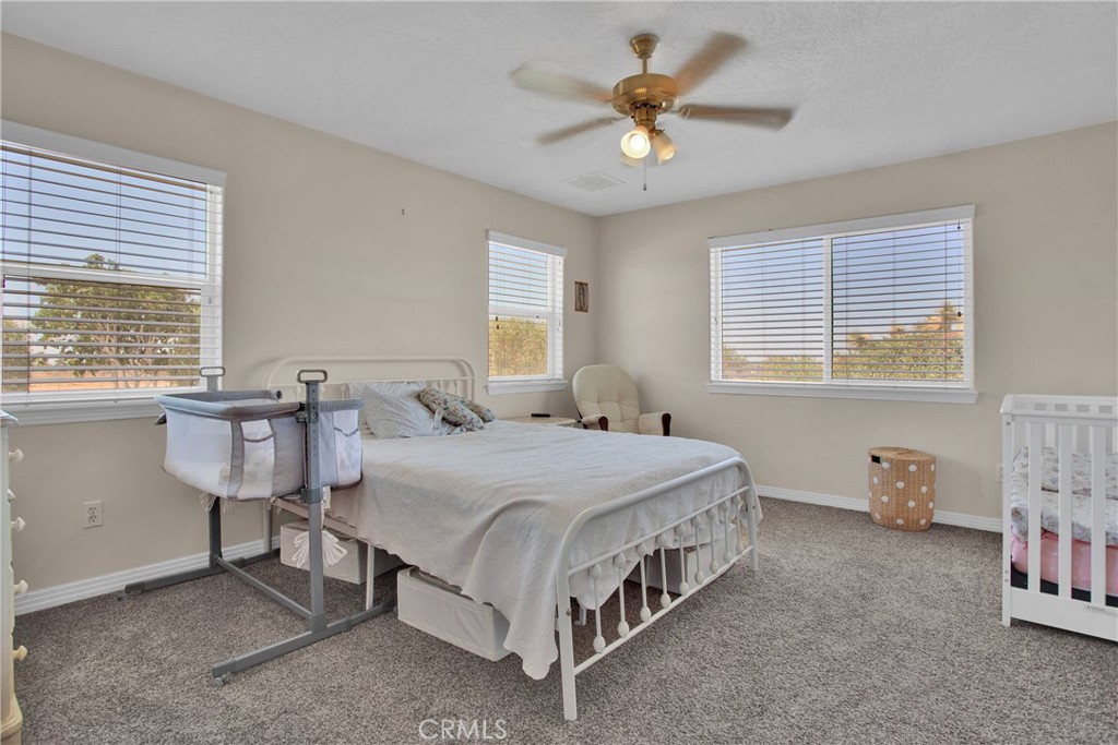 7330 Smoke Tree Road Phelan, CA 92371 - Photo 30 of 46 a spacious bedroom with a bed and a table in it