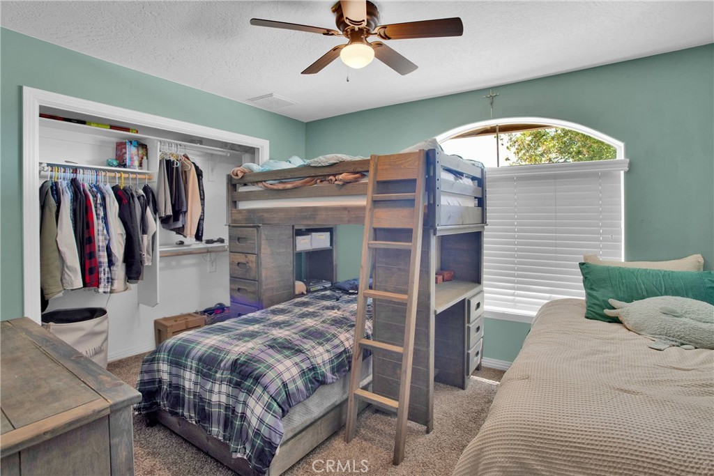 7330 Smoke Tree Road Phelan, CA 92371 - Photo 33 of 46 a bedroom with a bed and a chandelier