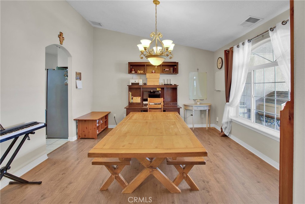 7330 Smoke Tree Road Phelan, CA 92371 - Photo 9 of 46 a dining room with furniture a chandelier and wooden floor