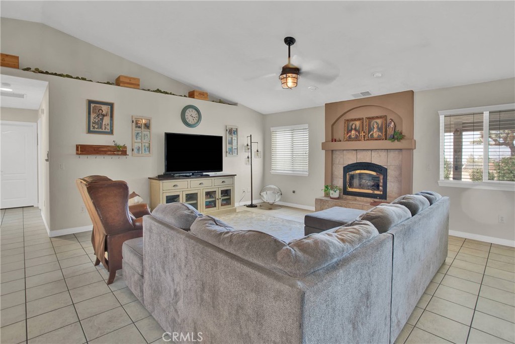 7330 Smoke Tree Road Phelan, CA 92371 - Photo 10 of 46 a living room with furniture a fireplace and a flat screen tv