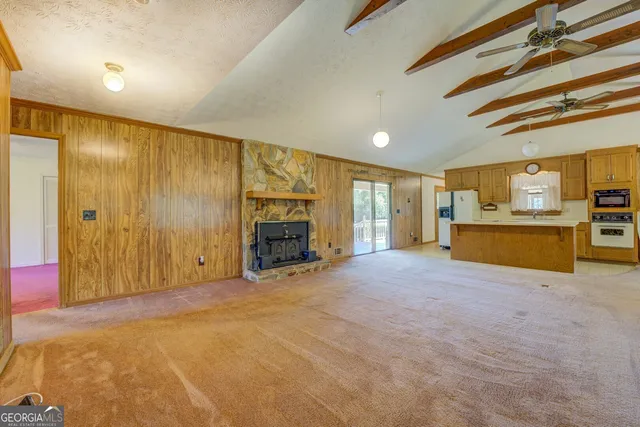 a view of an empty room with a fireplace and a window