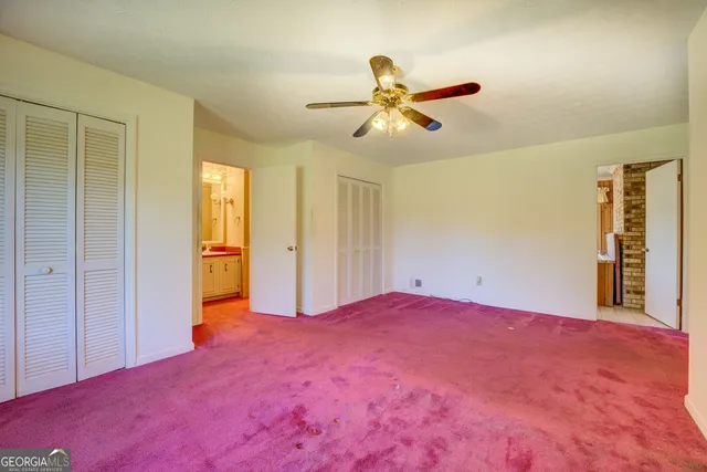 a view of empty room with window and ceiling fan