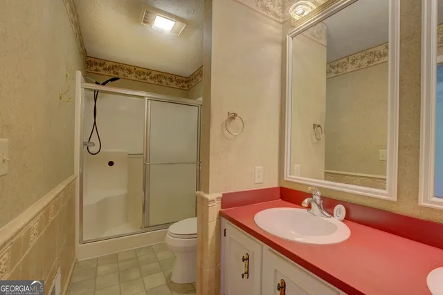 a bathroom with a sink a toilet and shower
