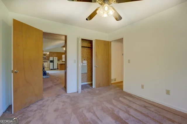 an empty room with fan and windows