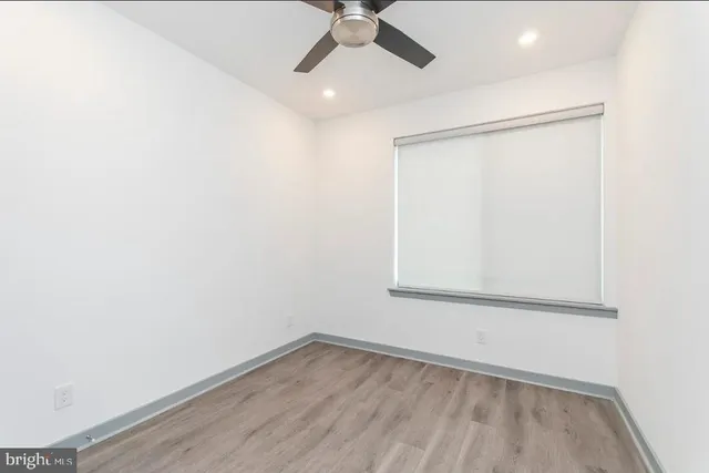 an empty room with a window and a ceiling fan