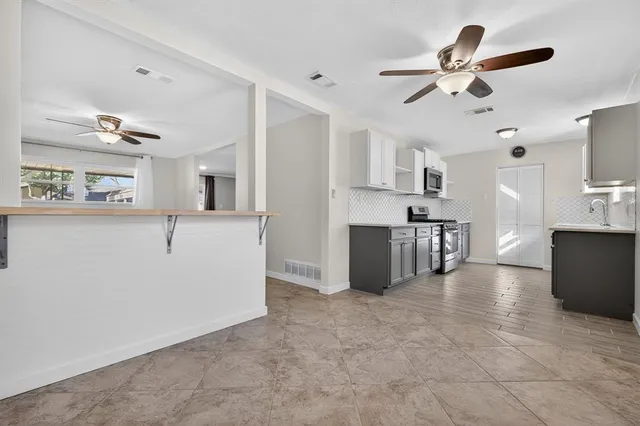 a kitchen with stainless steel appliances granite countertop a sink stove and microwave