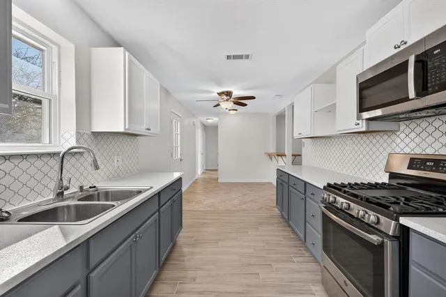 a kitchen with a sink stove top oven and cabinets