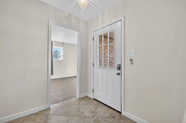 an empty room with wooden floor a ceiling fan and windows