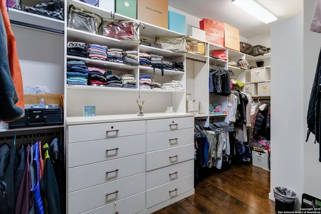 a view of walk in closet with clothes and shoes