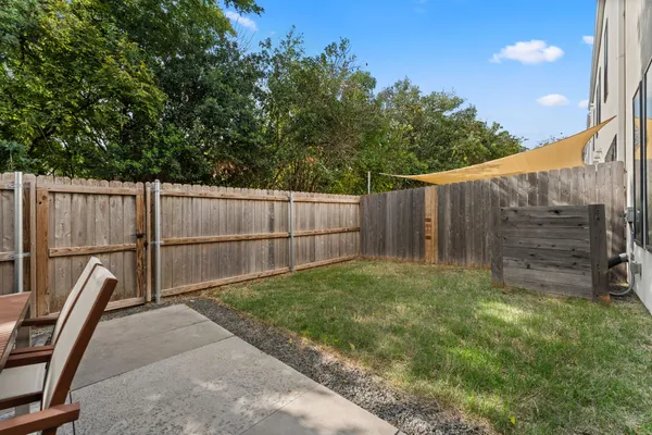 a view of backyard with wooden fence and trees