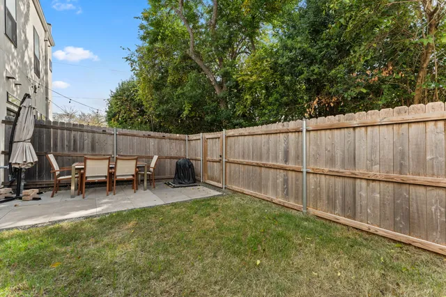 a view of backyard with wooden fence and a bench