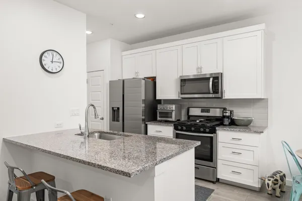 a kitchen with granite countertop a sink stove and refrigerator