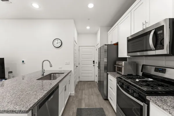 a kitchen with stainless steel appliances granite countertop a sink stove and refrigerator