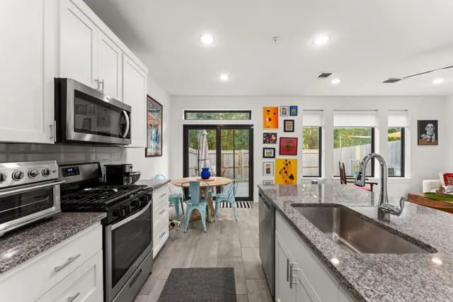 a kitchen with stainless steel appliances granite countertop a sink stove and refrigerator