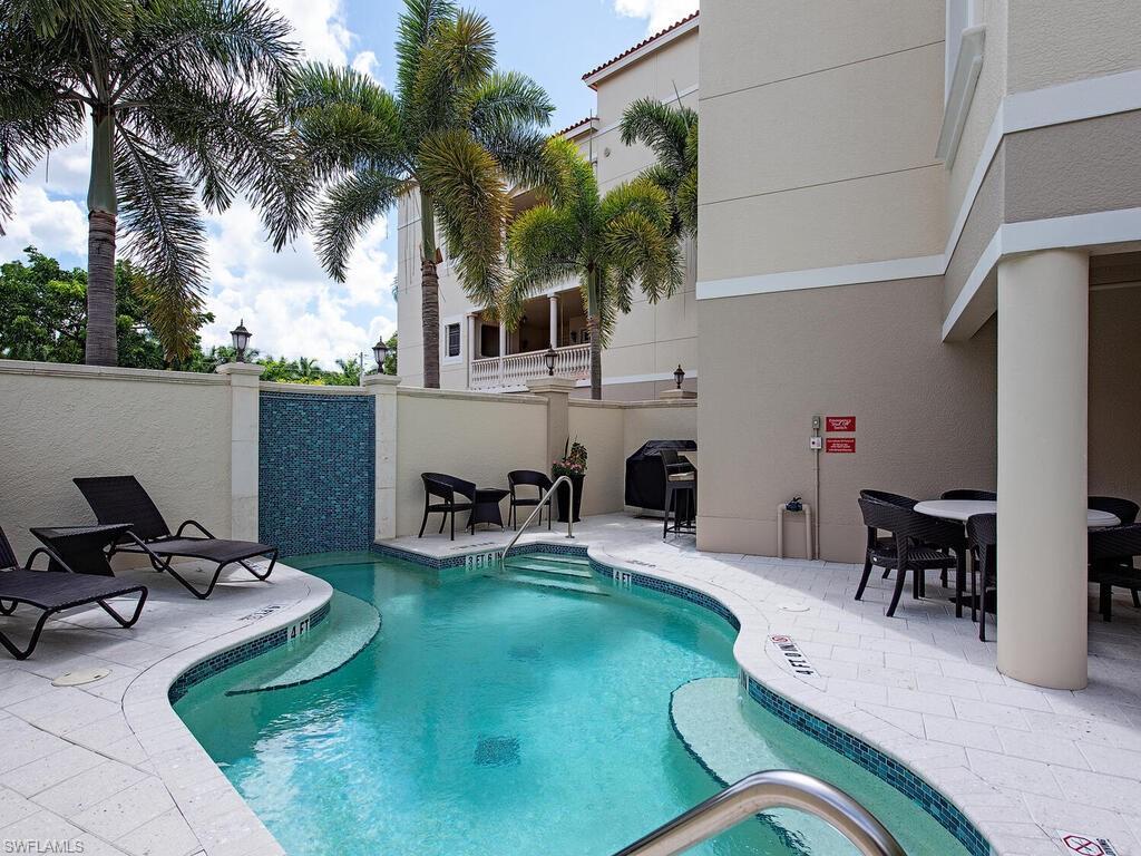 627 6th Avenue South, Unit B302 Naples, FL 34102 - Photo 13 of 14 a view of a patio with table and chairs potted plants and palm tree
