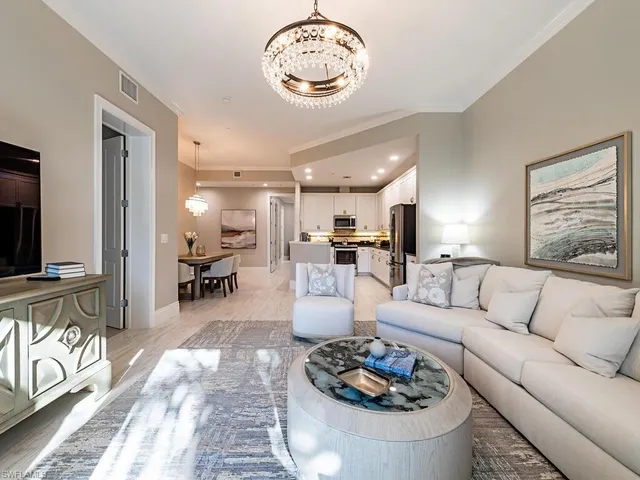 a living room with furniture kitchen view and a table