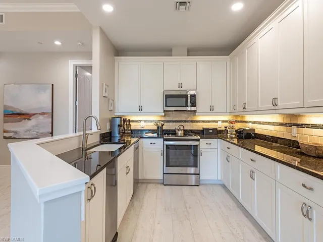 a kitchen with granite countertop a sink stove and cabinets