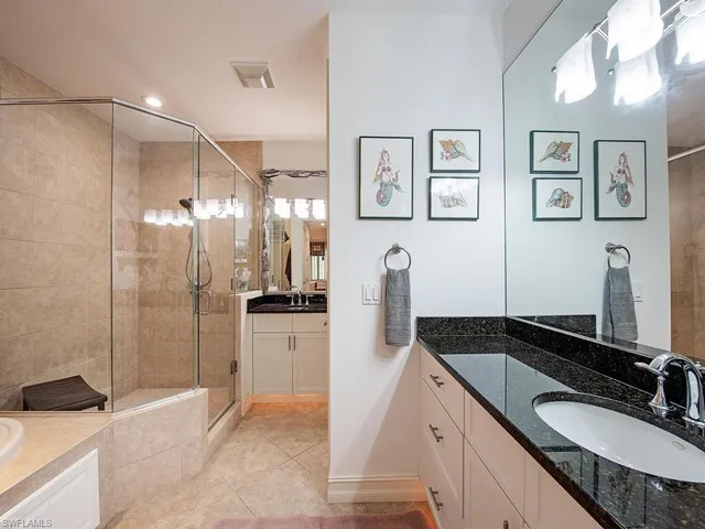 a bathroom with a granite countertop sink a mirror and a shower