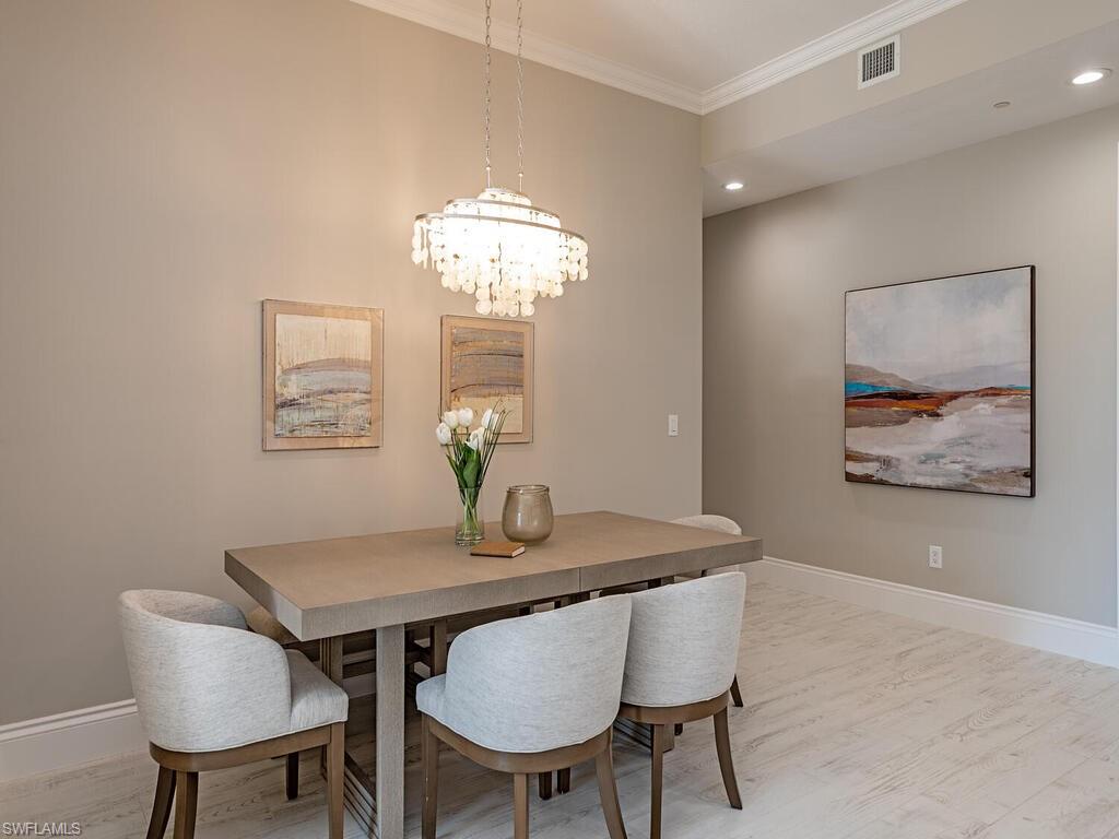 627 6th Avenue South, Unit B302 Naples, FL 34102 - Photo 8 of 14 a view of a dining room with furniture and chandelier
