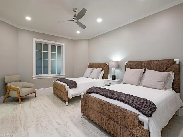 a bedroom with two beds and a large window