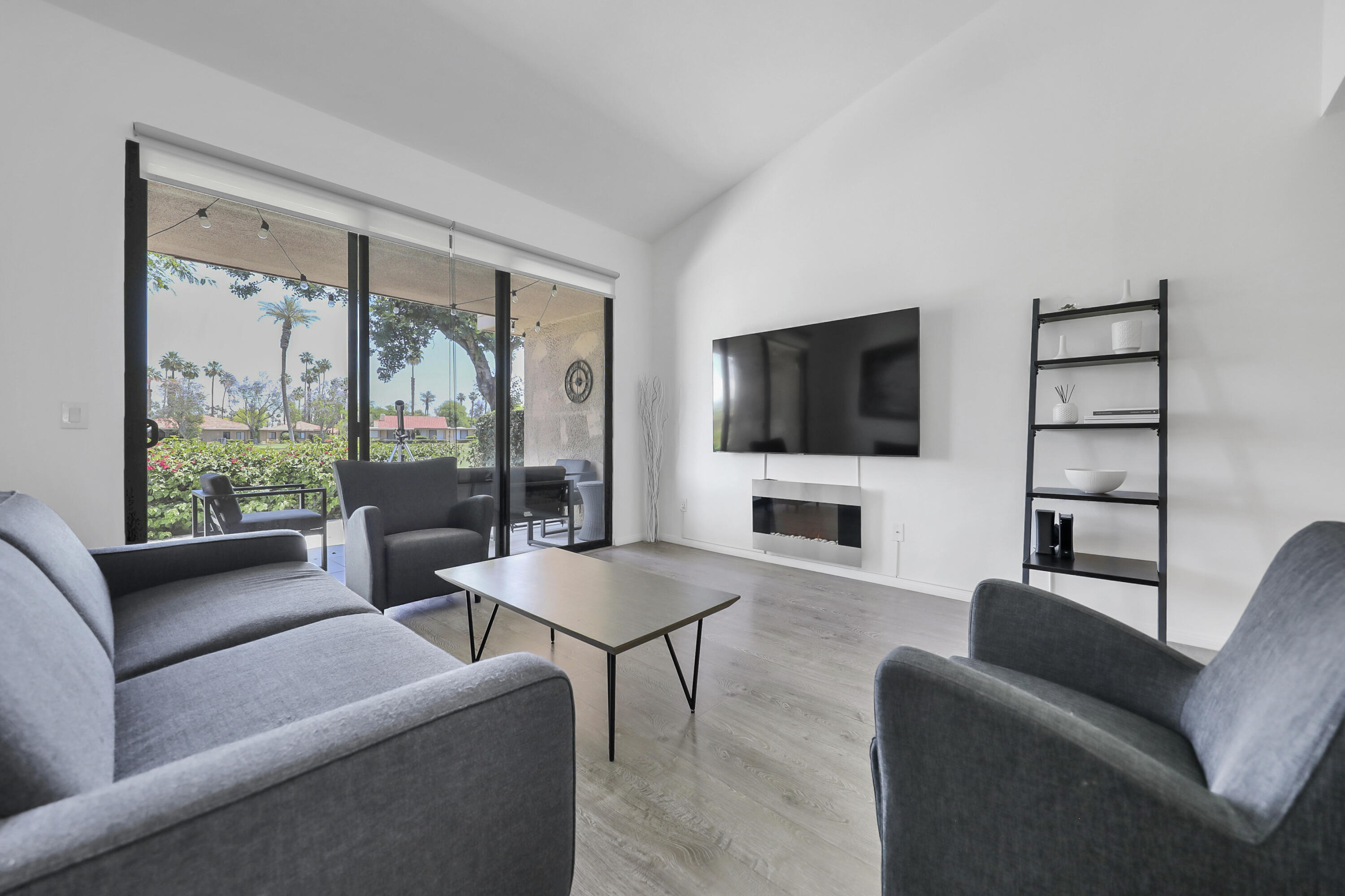 23 Haig Drive Rancho Mirage, CA 92270 - Photo 7 of 49 a living room with furniture a flat screen tv and a floor to ceiling window